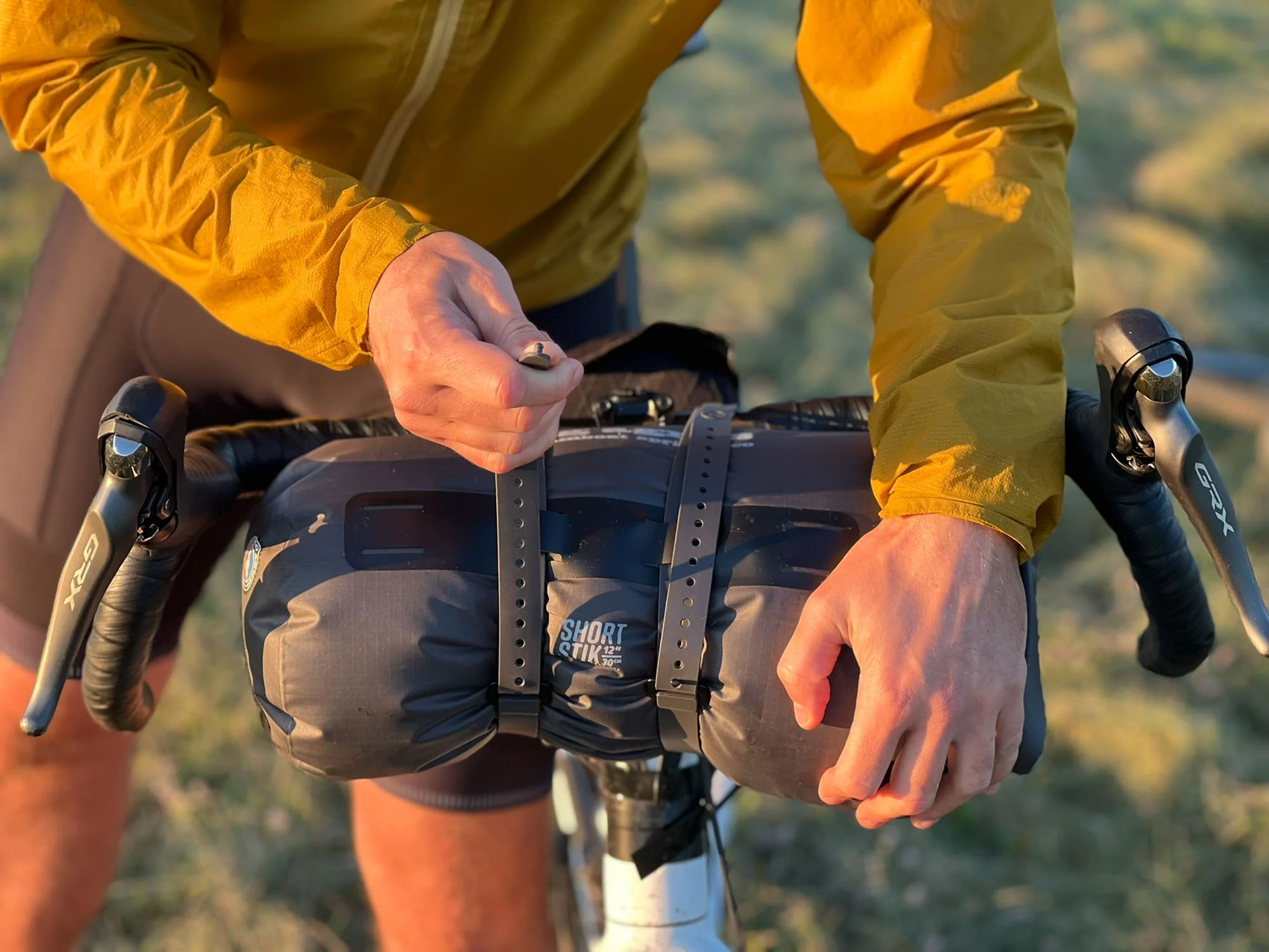 Kompresní obal se zkrácenými tyčkami stanu Big Agnes upevněný na řídítkách pomocí popruhů