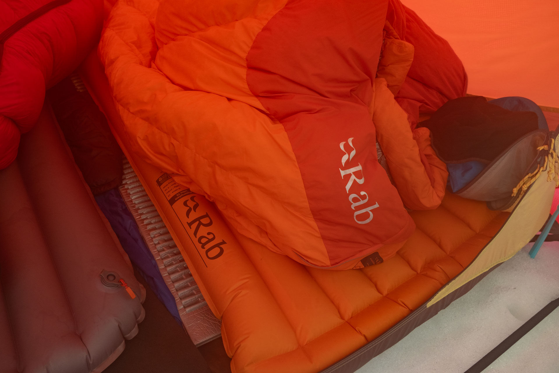 rozložený spacák Rab Andes a karimatka Rab Hypersphere ve stanu na sněhu
