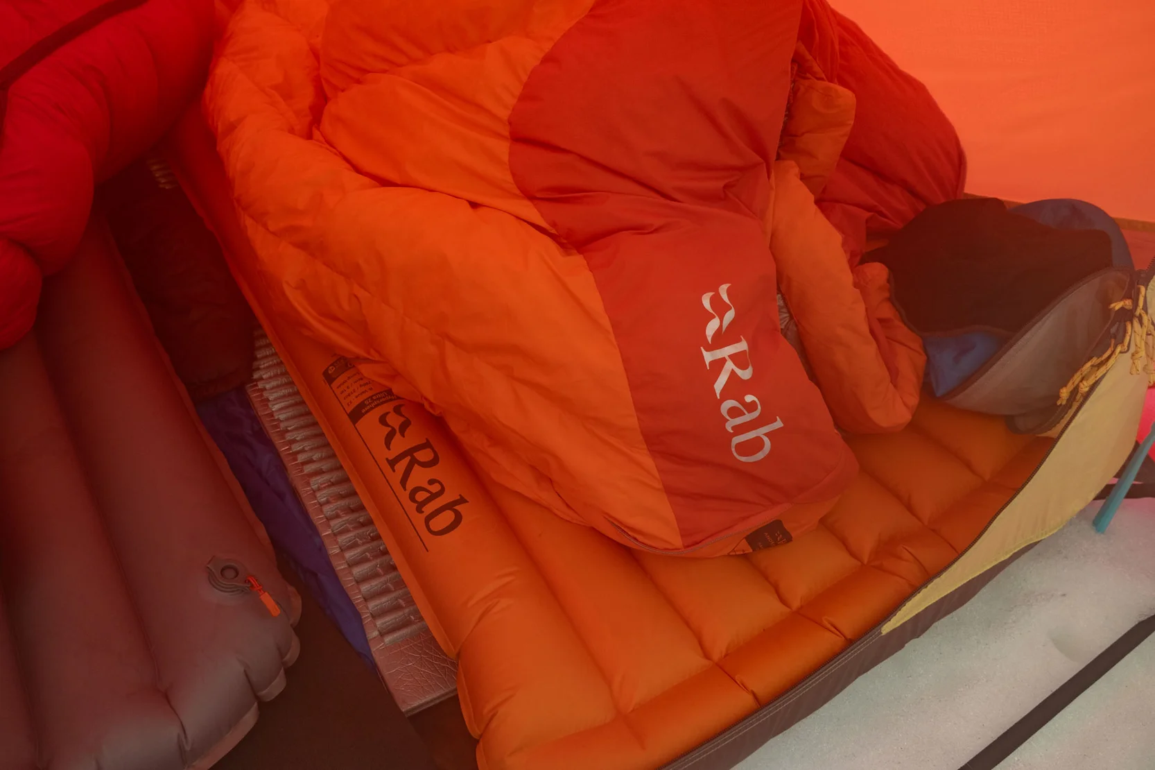 rozložený spacák Rab Andes a karimatka Rab Hypersphere ve stanu na sněhu