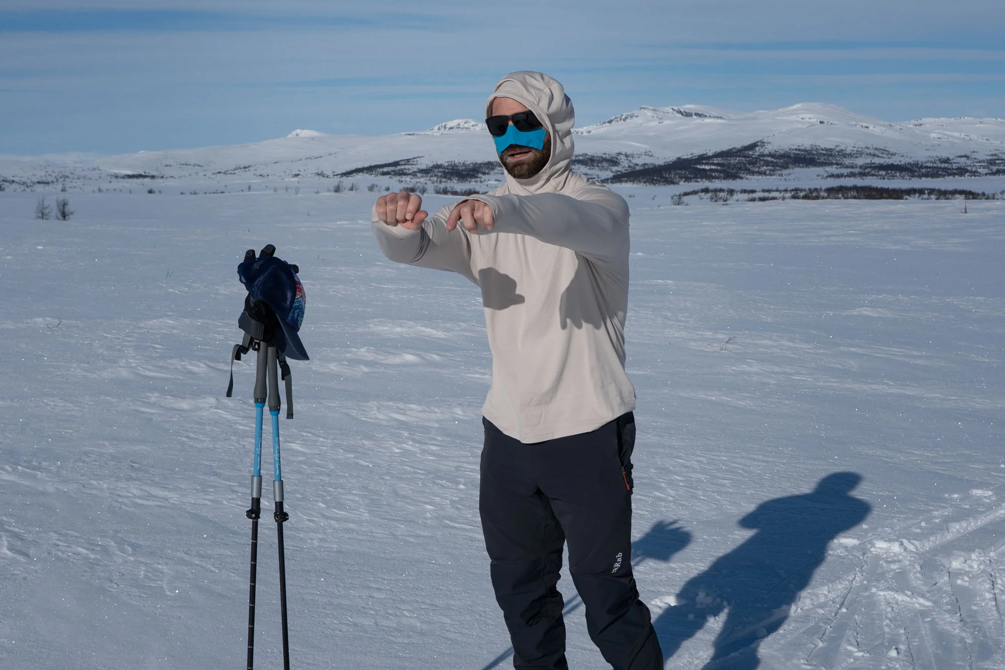 skialpinista v triku Rab Force Hoody na slunečném zimním treku